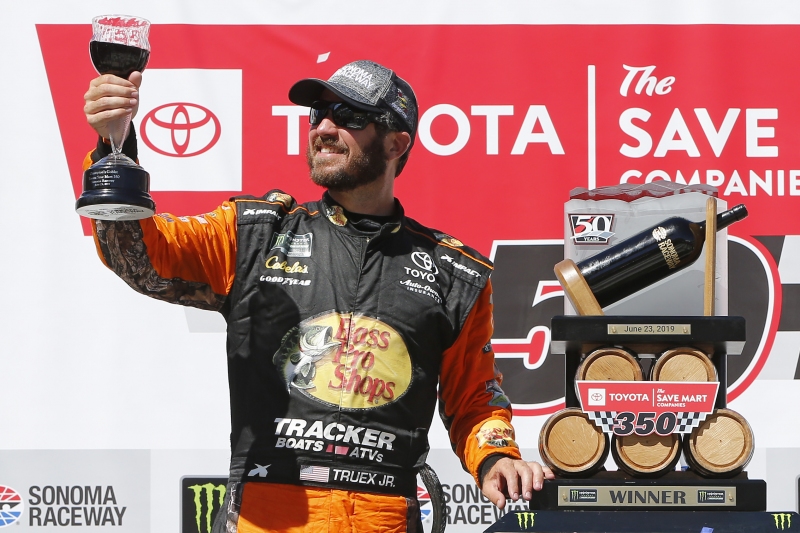 SONOMA, CALIFORNIA - JUNE 23: Martin Truex Jr., driver of the #19 Bass Pro Shops Toyota, poses with the trophy in Victory Lane after winning the Monster Energy NASCAR Cup Series Toyota/Save Mart 350 at Sonoma Raceway on June 23, 2019 in Sonoma, California. (Photo by Jonathan Ferrey/Getty Images)
