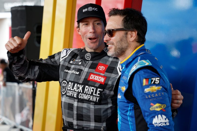 Travis Pastrana, driver of the #67 Black Rifle Coffee Toyota, (L) and Jimmie Johnson, driver of the #84 Carvana Chevrolet, pose for photos backstage during pre-race ceremonies prior to the NASCAR Cup Series 65th Annual Daytona 500 at Daytona International Speedway on February 19, 2023 in Daytona Beach, Florida. (Photo by Jared C. Tilton/Getty Images)
