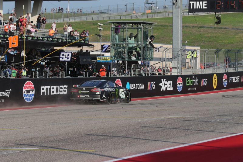 Mar 26, 2023; Austin, Texas, USA;  NASCAR Cup Series driver Tyler Reddick (45) takes the checked flag during the EchoPark Automotive Grand Prix at the Circuit of the Americas. Credit: Michael C. Johnson