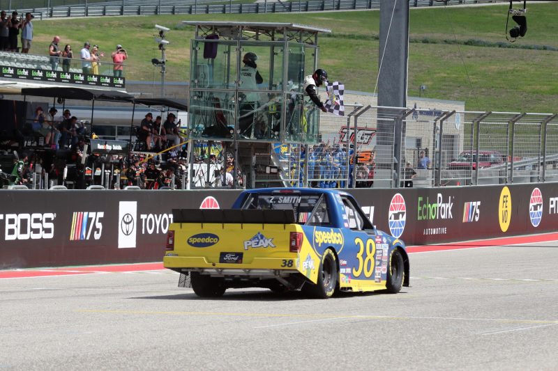 Mar 25, 2023; Austin, Texas, USA;  NASCAR Craftsman Truck Series driver Zane Smith takes the checked flag in the XPEL 225 at the Circuit of the Americas. Credit: Michael C. Johnson